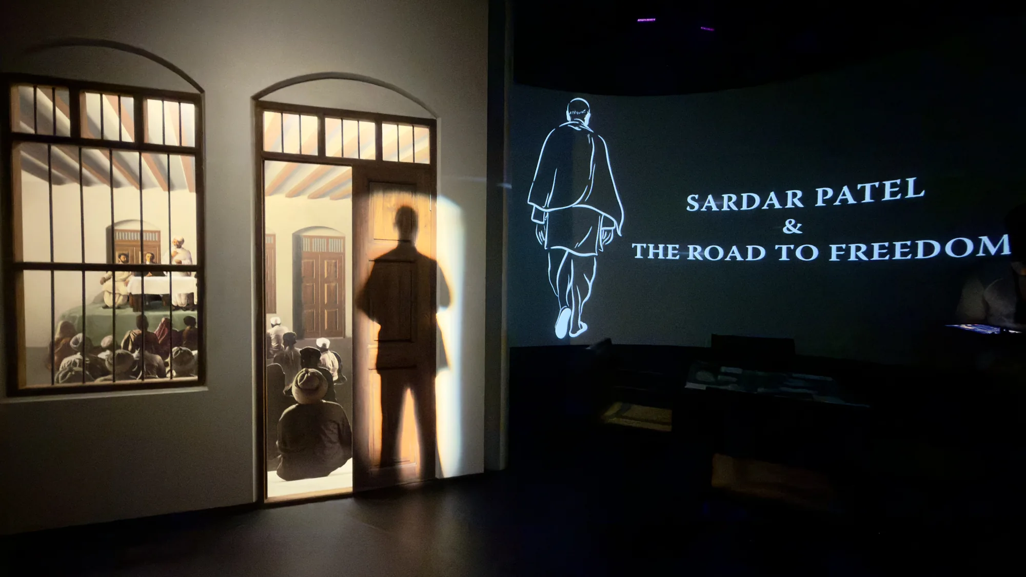 Museum: projection through a doorway, a figure walks into the title